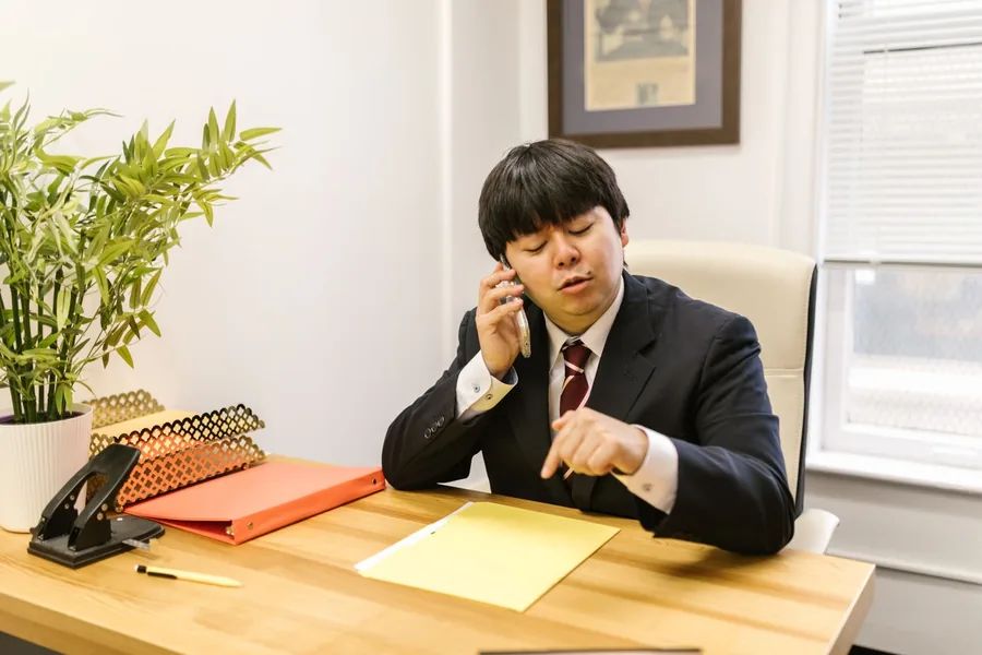 電話で相談を受けている執務室の様子